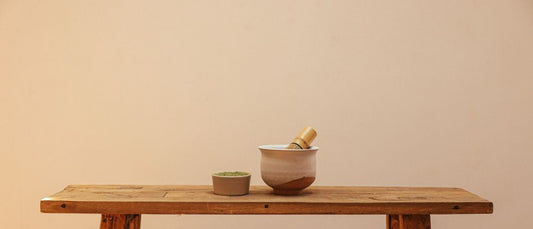 Matcha grain with matcha whisk and bowl on a bench
